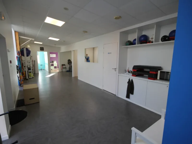 Accueil et salle commune du cabinet de kinésithérapie avec espace d'exercices et prise en charge personnalisée.